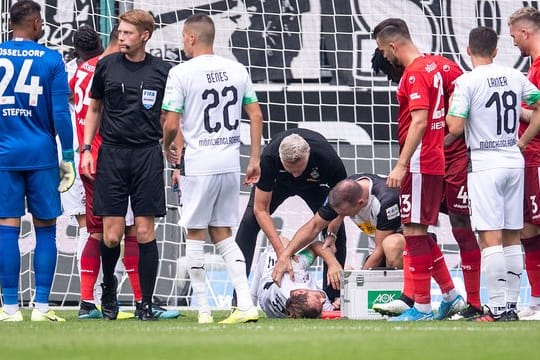 Gladbachs Tony Jantschke liegt nach einem Zusammenprall auf dem Rasen und wird betreut.