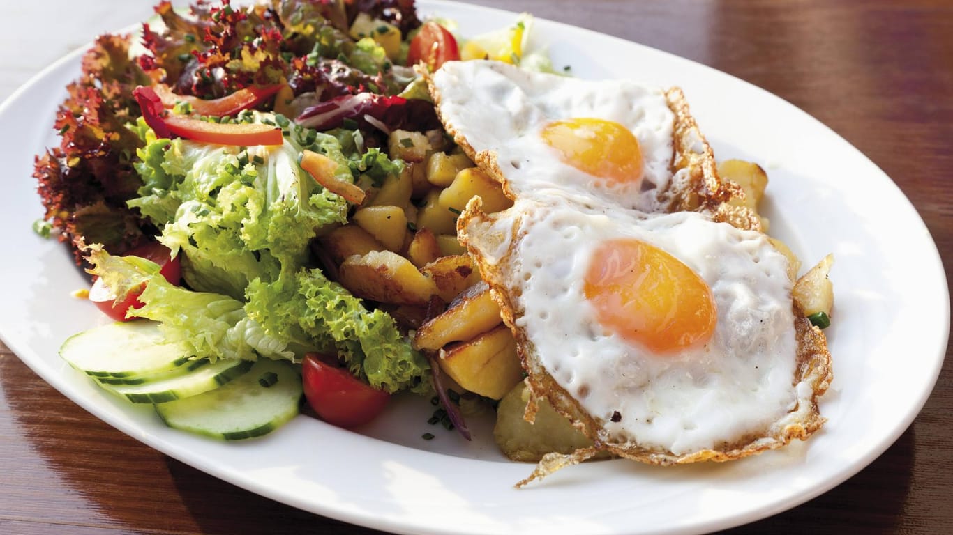 Bratkartoffeln mit Spiegeleiern und Salatbeilage: Deutsche Hausmannskost lässt keine Wünsche offen.