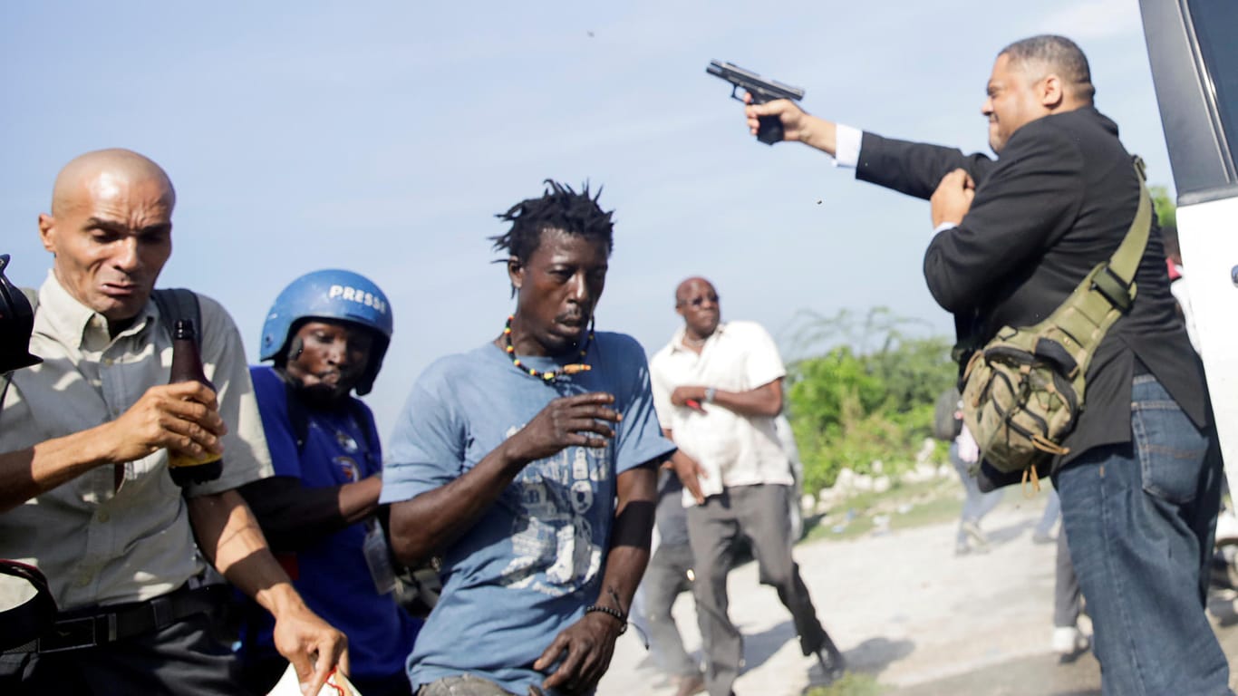 Jean-Marie Ralph Féthière schießt um sich: Vor dem Parlament in Haiti gerieten Menschen in Aufruhr.