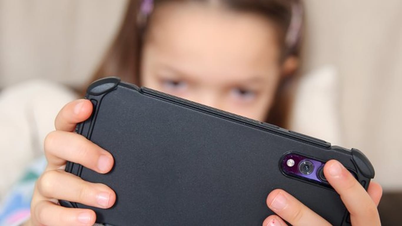 Ein Kind am Smartphone: Viele Kinder spielen gerne am Handy – und treffen dabei nicht immer auf kindgerechte Inhalte.