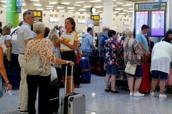 Reisende und Thomas Cook-Mitarbeiter am Flughafen: Etwa 150.000 Briten sind im Ausland von der Pleite des Reisekonzerns betroffen.