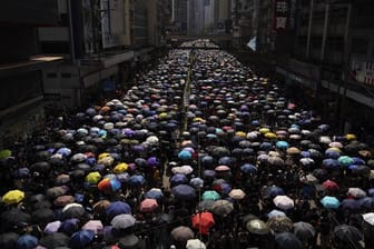 Anhänger der Demokratiebewegung ziehen mit Regenschirmen durch Hongkong.