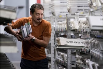 Ein Postangestellter in den USA sortiert Sendungen: Washington beschwert sich seit Jahren über die niedrigen Portogebühren für Warensendungen aus dem Ausland.