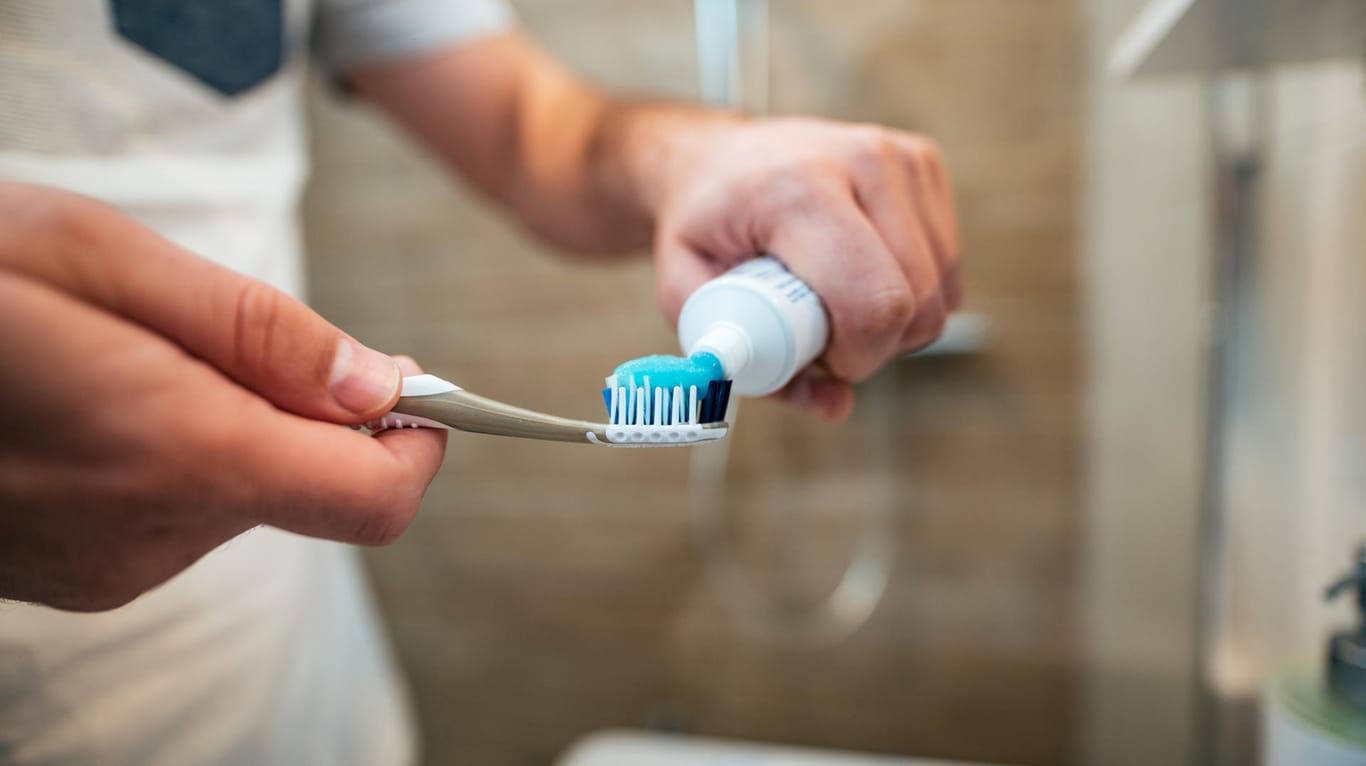 Ein Mann macht Zahnpasta auf eine Zahnbürste: Die Prüfer von der Stiftung Warentest sind von einigen Zahnpasten überzeugt.