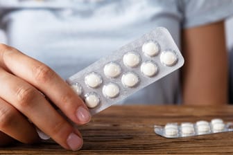 Frau hält Tablettenpackung: Magensäureblocker werden meist gegen Sodbrennen eingenommen.