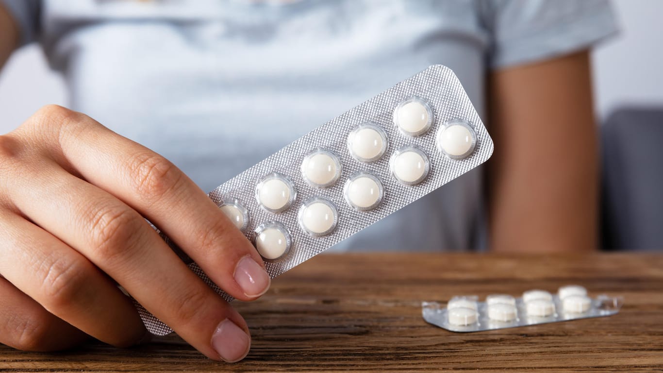 Frau hält Tablettenpackung: Magensäureblocker werden meist gegen Sodbrennen eingenommen.