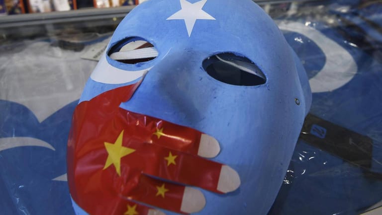 Symbol des Protests: Diese Maske zeigt die Nationalflagge von Ost-Turkestan. Die chinesische Flagge ist als vorgehaltene Hand aufgeklebt. Nur Exil-Uiguren können im Ausland demonstrieren.