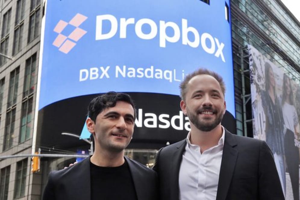 Arash Ferdowsi (l) und Drew Houston, Gründer des Online-Speicherdienstes Dropbox, stehen vor einem Plakat zum Börsengang ihres Unternehmens.