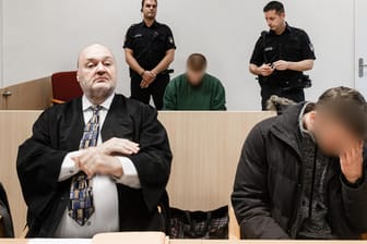 Prozess um die Vergiftung eines VermietersAnwalt und zwei Angeklagte vor dem Gericht in Lübeck: Ein Angeklagter soll seinen im selben Haus wohnenden Vermieter mit einem Pflanzenschutzmittel vergiftet haben.