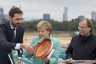 Bundeskanzlerin Agela Merkel (M) packt bei der Grundsteinlegung zur DFB-Akademie mit an.