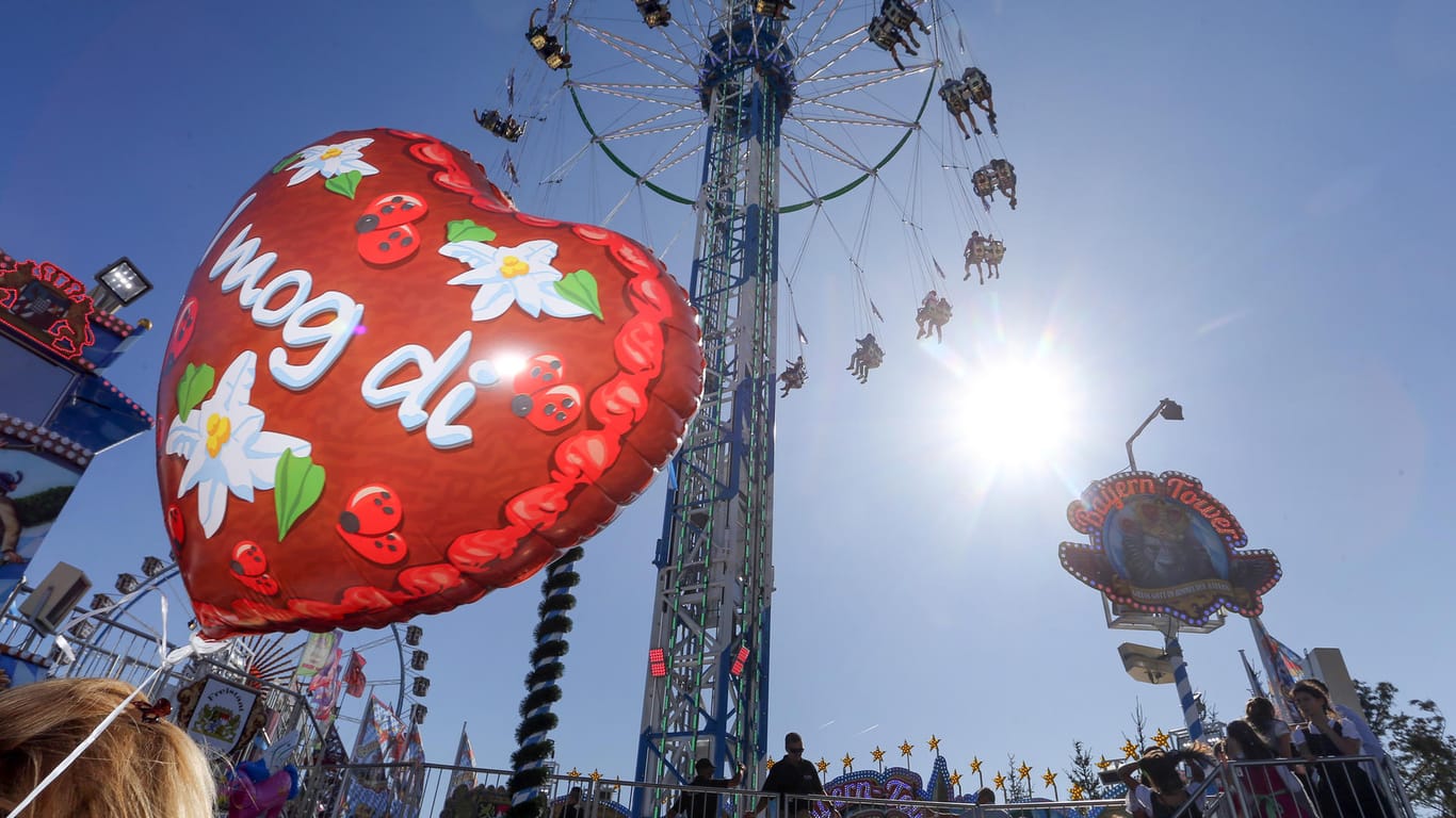 Hinter einem Luftballon dreht sich ein Riesen-Kettenkarussell: Wind und Regen bestimmen das Wetter am Wochenende – aber über dem Münchner Oktoberfest scheint die Sonne.