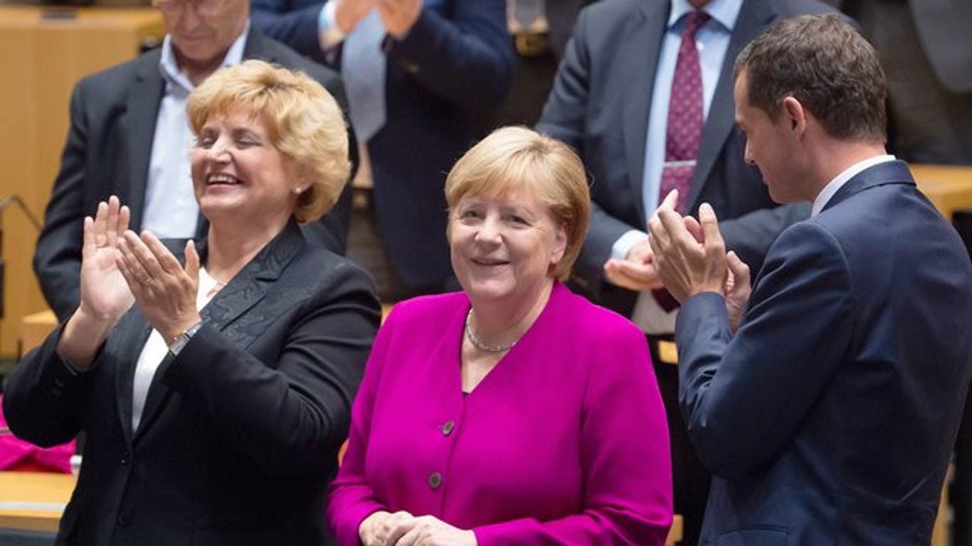 Birgit Diezel (CDU), Landtagspräsidentin (l), und Mike Mohring, CDU-Fraktionschef, applaudieren Bundeskanzlerin Angela Merkel (CDU, M) auf dem Festakt der Thüringer CDU-Landtagsfraktion zum Tag der Deutschen Einheit im Thüringer Landtag.
