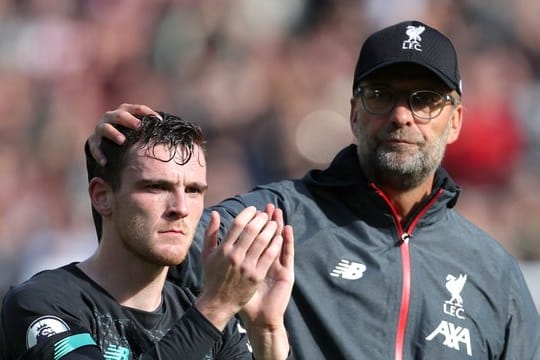 Trainer Jürgen Klopp tätschelt seinem Spieler Andrew Robertson nach dem Spiel den Kopf.