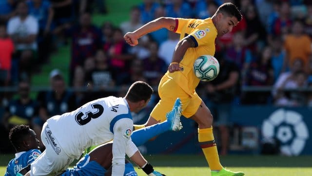 Barcelonas Luis Suarez (r) kämpft mit Getafes Torhüter David Soria (M) und Getafes Djene Dakonam um den Ball. Barcelonas Luis Suarez (r) kämpft mit Getafes Torhüter David Soria (M) und Getafes Djene Dakonam um den Ball.