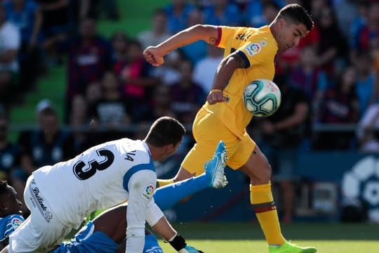 Barcelonas Luis Suarez (r) kämpft mit Getafes Torhüter David Soria (M) und Getafes Djene Dakonam um den Ball.