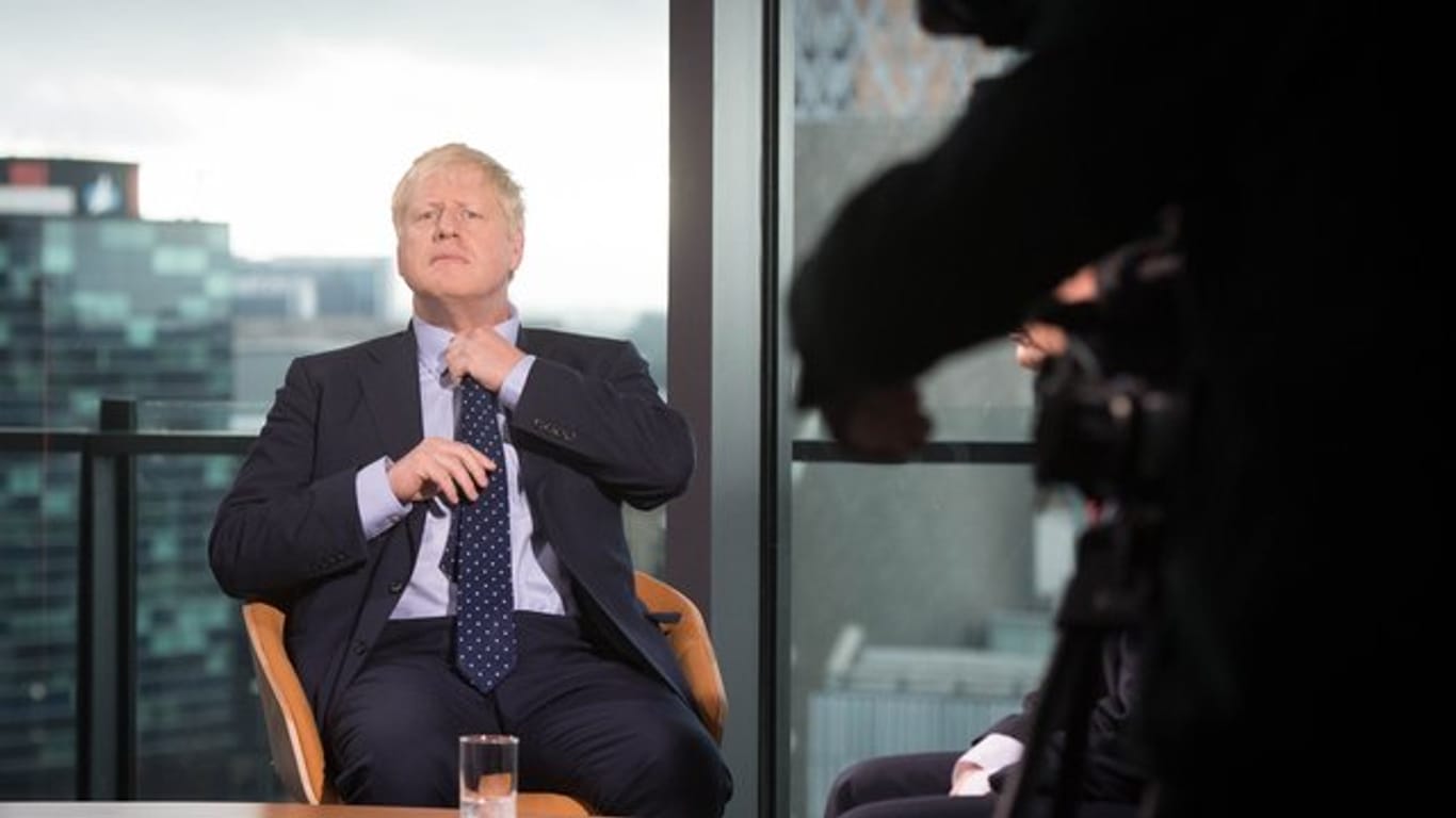 Premier Boris Johnson richtet seine Krawatte vor seinem Auftritt in der Andrew Marr Show auf dem Sender BBC in Media City in Salford.