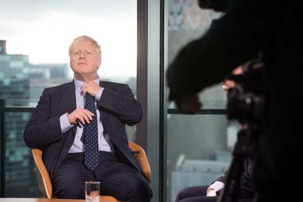 Premier Boris Johnson richtet seine Krawatte vor seinem Auftritt in der Andrew Marr Show auf dem Sender BBC in Media City in Salford.