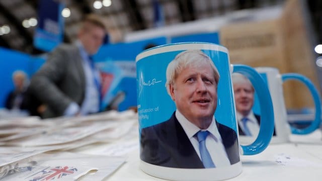 Tassen mit dem Gesicht von Premierminister Boris Johnson auf dem Parteitag.