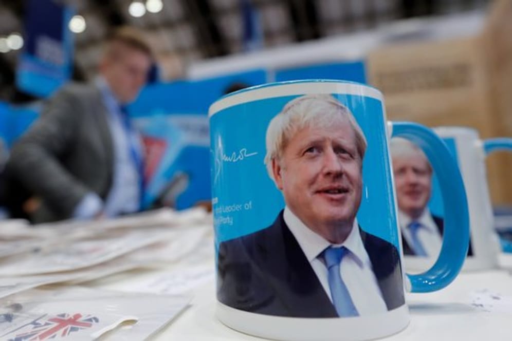 Tassen mit dem Gesicht von Premierminister Boris Johnson auf dem Parteitag.