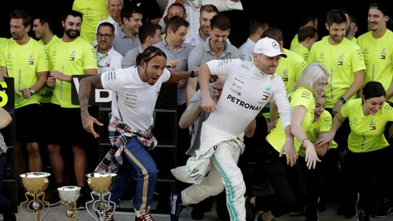 Lewis Hamilton (l) und Valtteri Bottas feiern mit dem Mercedes-Team den ersten und zweiten Platz in Sotschi.