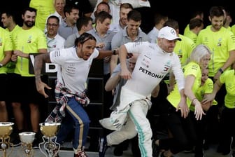 Lewis Hamilton (l) und Valtteri Bottas feiern mit dem Mercedes-Team den ersten und zweiten Platz in Sotschi.