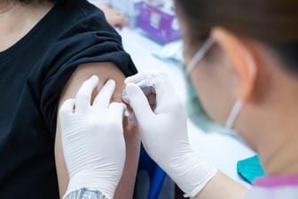 Patientin bekommt eine Impfung: Bereits im Oktober oder November sollte eine Grippeimpfung erfolgen.