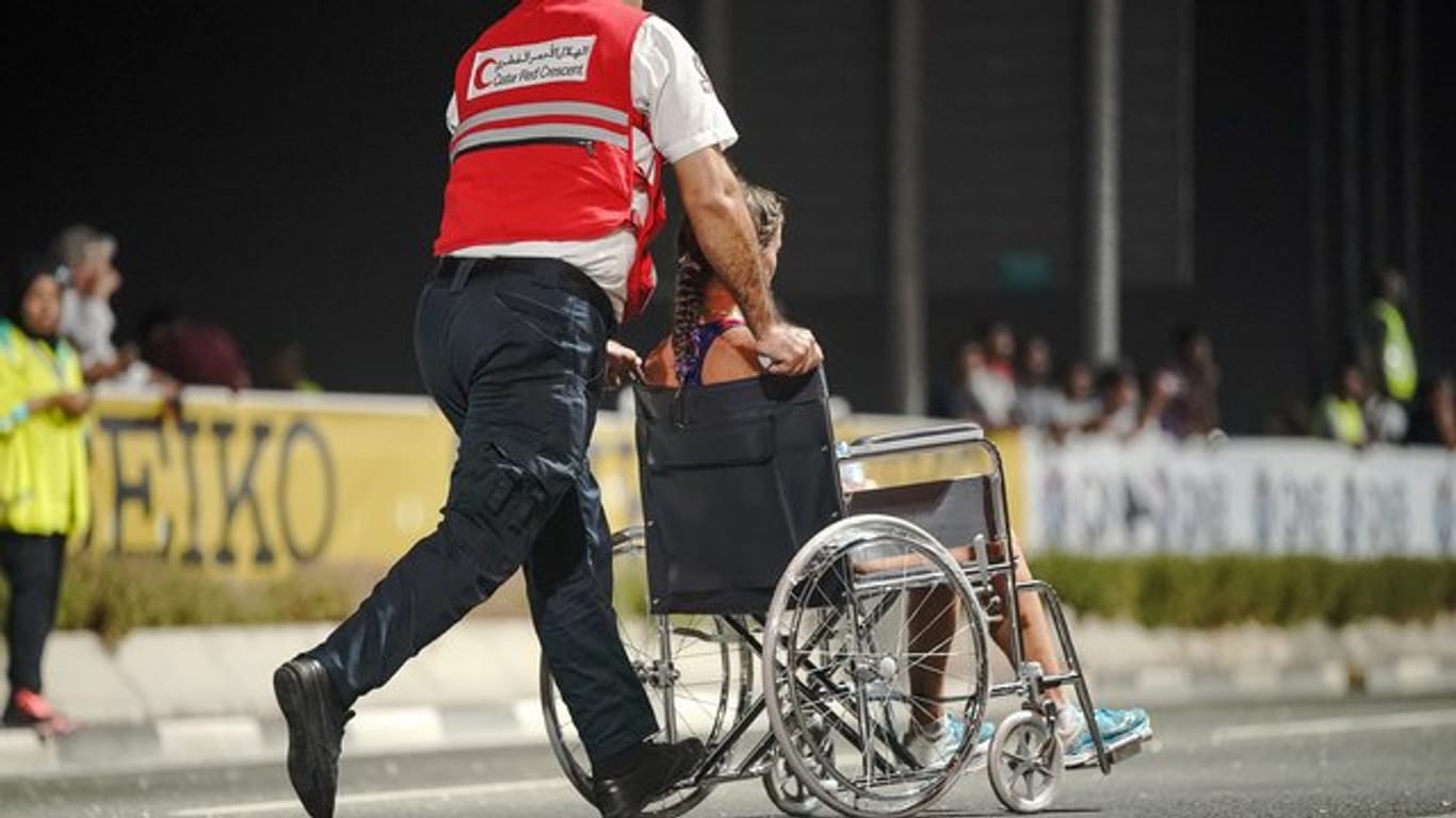 Nur 40 der 68 gestarteten Teilnehmerinnen kamen beim Marathon in Doha ins Ziel: Ein Sanitäter bringt eine erschöpfte Läuferin von der Strecke.