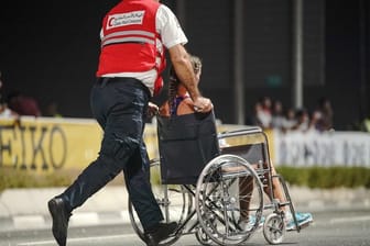 Nur 40 der 68 gestarteten Teilnehmerinnen kamen beim Marathon in Doha ins Ziel: Ein Sanitäter bringt eine erschöpfte Läuferin von der Strecke.