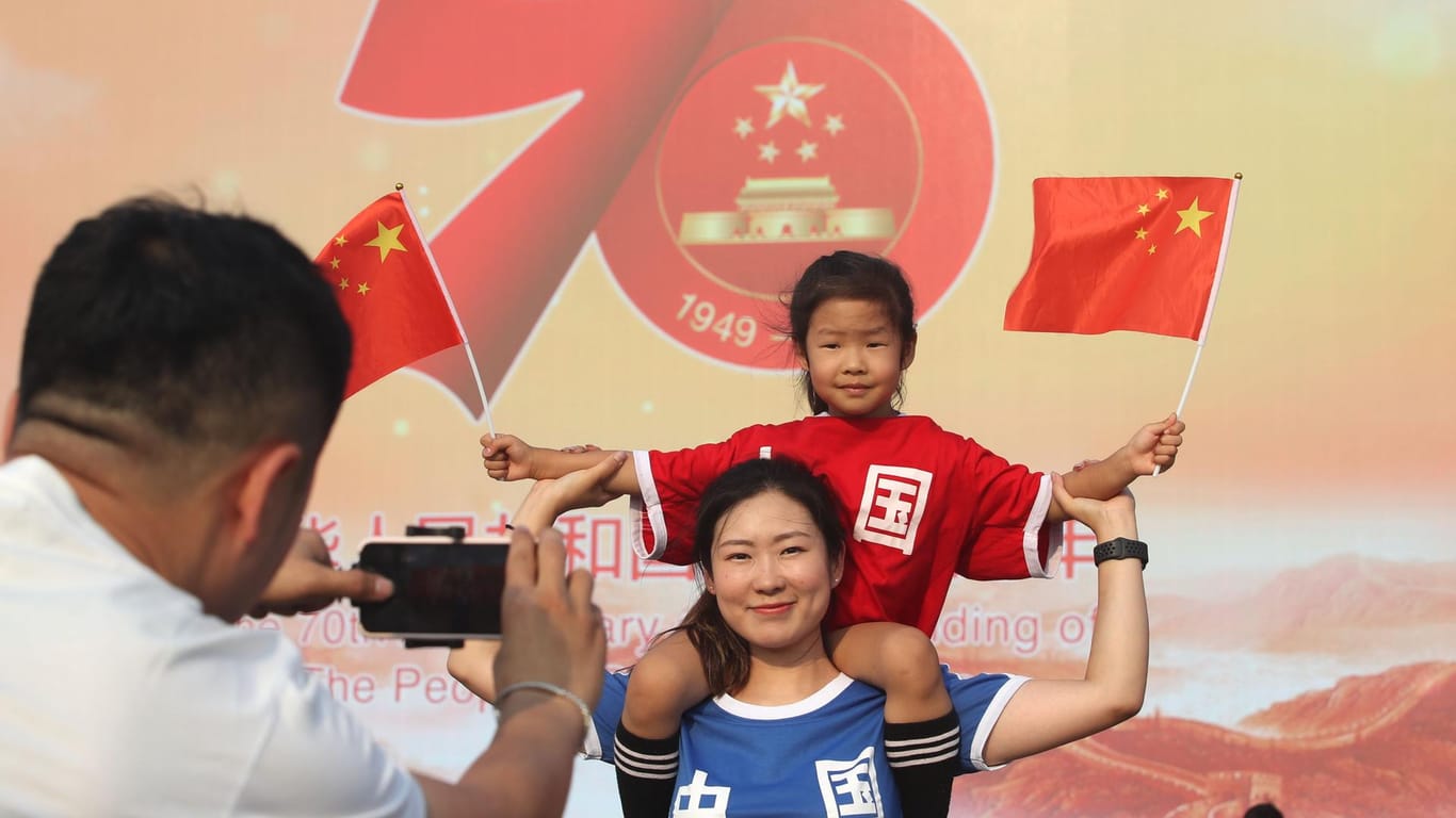 Patriotische Touristen auf dem Tiananmen-Platz in Peking.