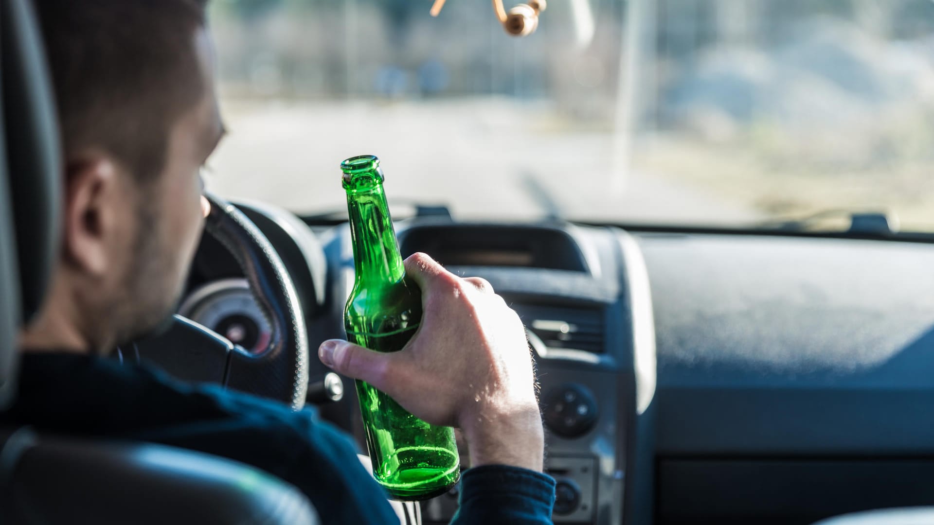 Ein Autofahrer trinkt Bier: Wer mit Alkohol am Steuer erwischt wurde, braucht oft einen Abstinenznachweis, um wieder Auto fahren zu dürfen.