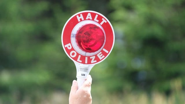 Eine Polizistin hält eine Winkerkelle in die Höhe