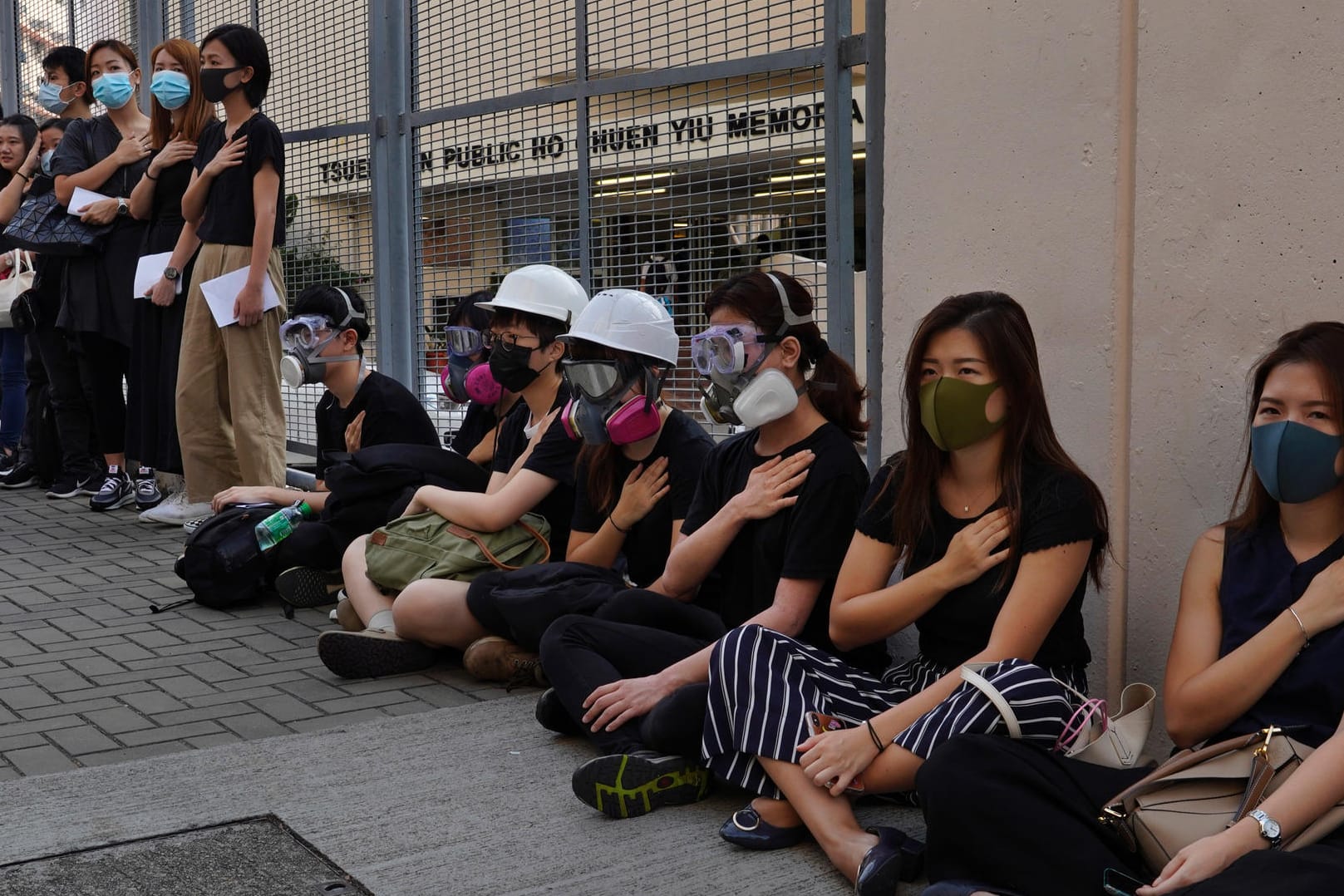 Studenten halten in einer symbolischen Geste eine Hand aufs Herz: Erstmals ist bei den Protesten in Hongkong ein Demonstrant mit scharfer Munition verletzt worden.