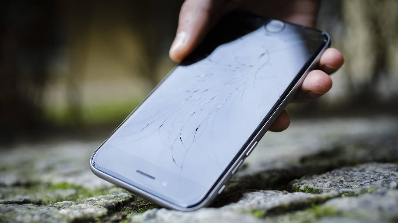 Das Apple iPhone mit zersplittertem Glas wird von der Strasse aufgehoben: Smartphones gehen nicht nur beim Herunterfallen zu Bruch.