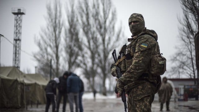 Ein ukrainischer Soldat patrouilliert an einem Stützpunkt für humanitäre Hilfe in der Ostukraine. Ein ukrainischer Soldat patrouilliert an einem Stützpunkt für humanitäre Hilfe in der Ostukraine.