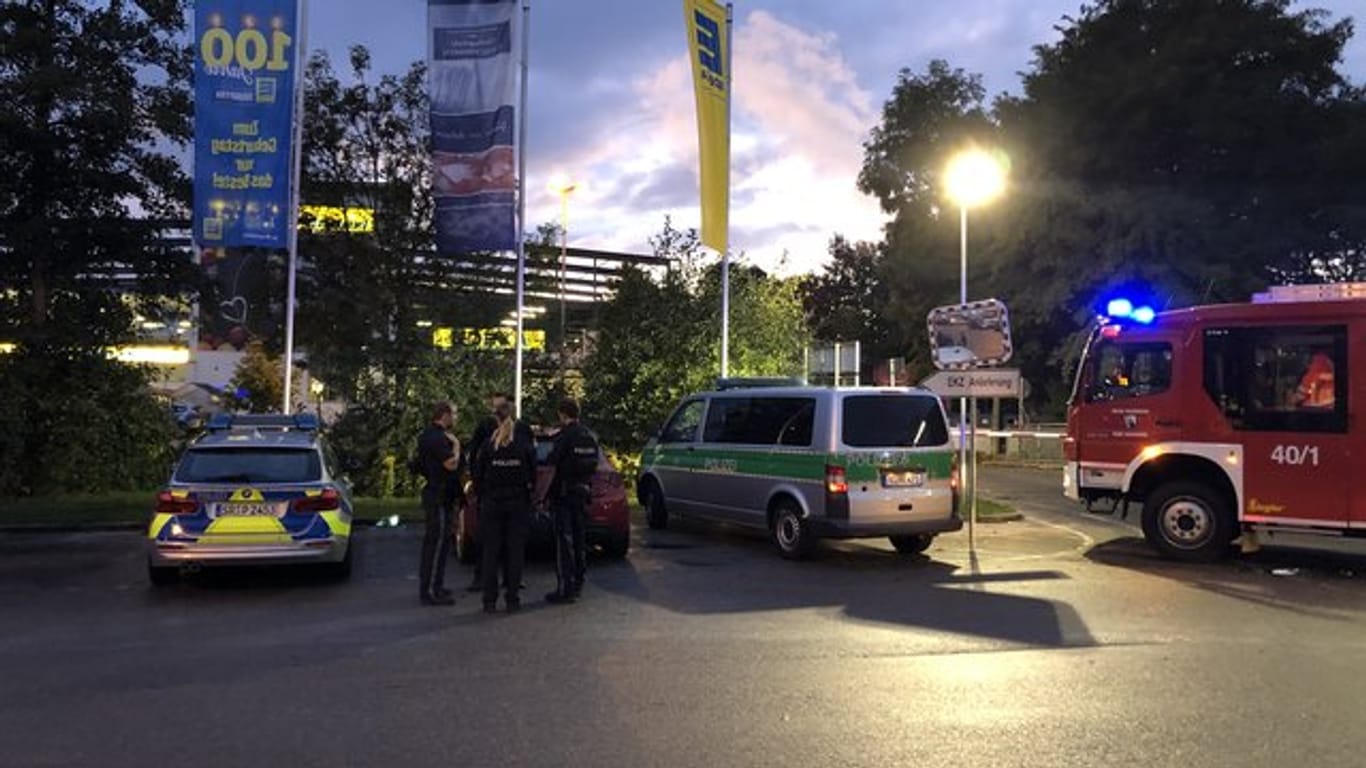 Fahrzeuge von Polizei und Feuerwehr stehen auf dem Parkplatz des Supermarktes in Abensberg.