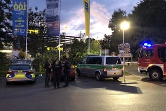 Fahrzeuge von Polizei und Feuerwehr stehen auf dem Parkplatz des Supermarktes in Abensberg.