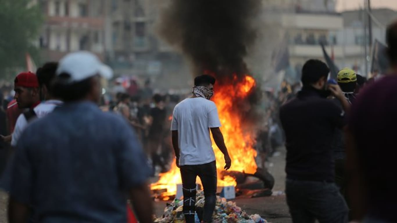 Demonstranten verbrennen Reifen während eines Protestes in Bagdad.