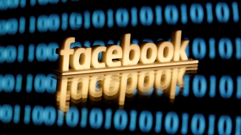 Das Facebook-Logo ist vor einem Bildschirm mit Einsen und Nullen zu sehen: Die Kommunikation auf der Plattform soll sicherer werden.