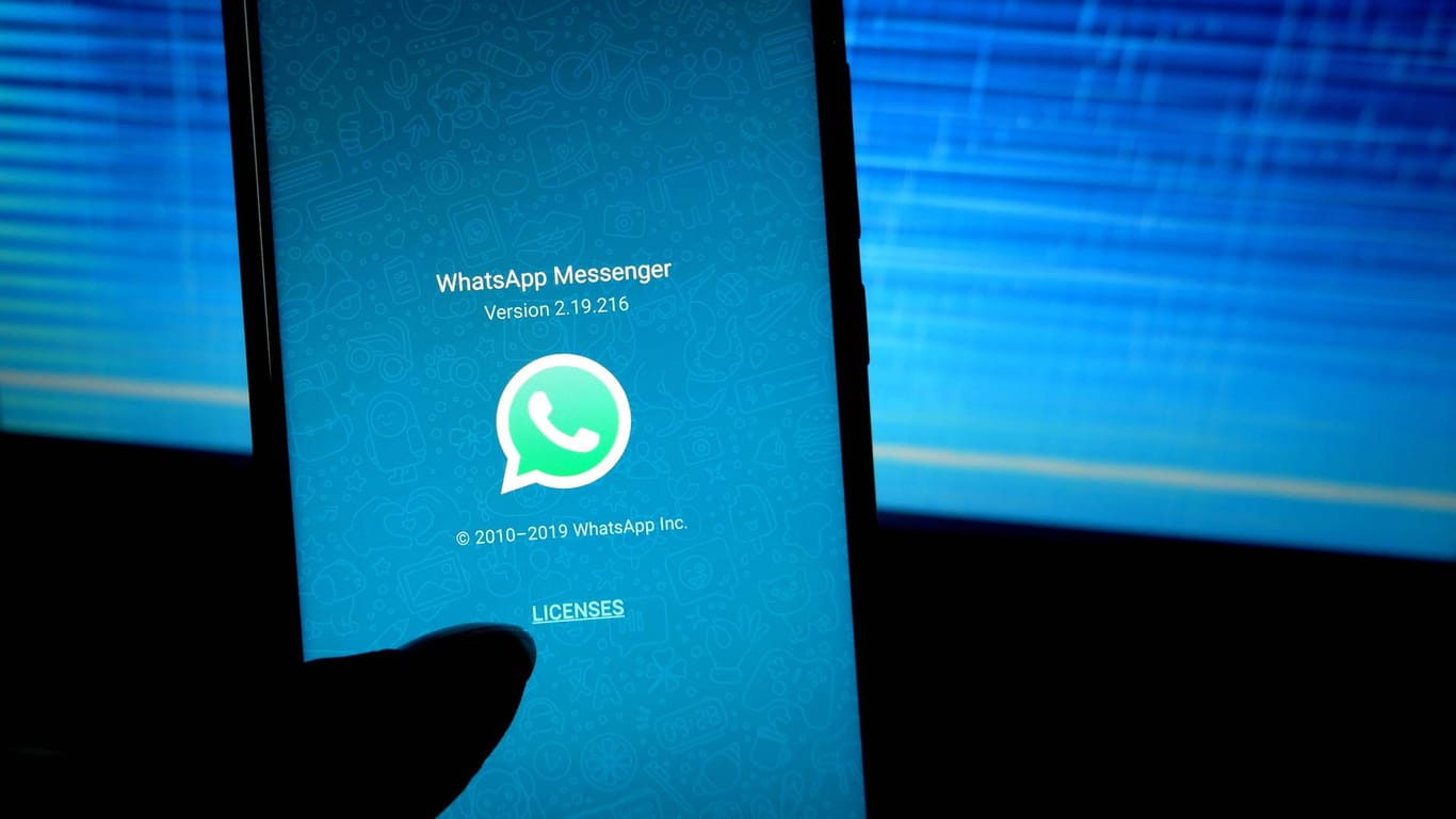 Ein Smartphone mit WhatsApp wird vor einen Bildschirm gehalten: In dem Messenger gab es ein Problem mit GIFs.