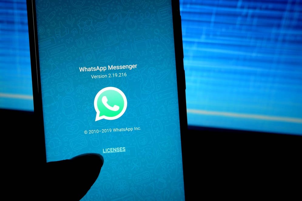 Ein Smartphone mit WhatsApp wird vor einen Bildschirm gehalten: In dem Messenger gab es ein Problem mit GIFs.