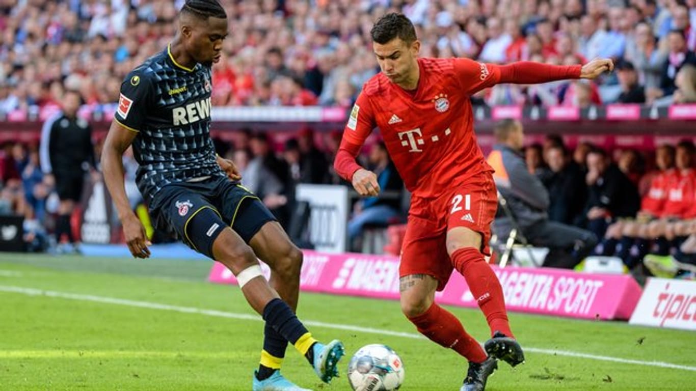 Bayerns Lucas Hernandez (r) im Zweikampf mit Kölns Kingsley Ehizibue um den Ball.