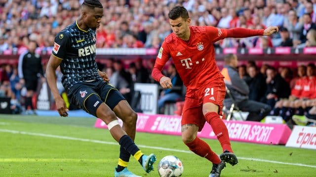 Bayerns Lucas Hernandez (r) im Zweikampf mit Kölns Kingsley Ehizibue um den Ball. Bayerns Lucas Hernandez (r) im Zweikampf mit Kölns Kingsley Ehizibue um den Ball.