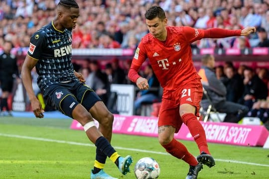 Bayerns Lucas Hernandez (r) im Zweikampf mit Kölns Kingsley Ehizibue um den Ball.