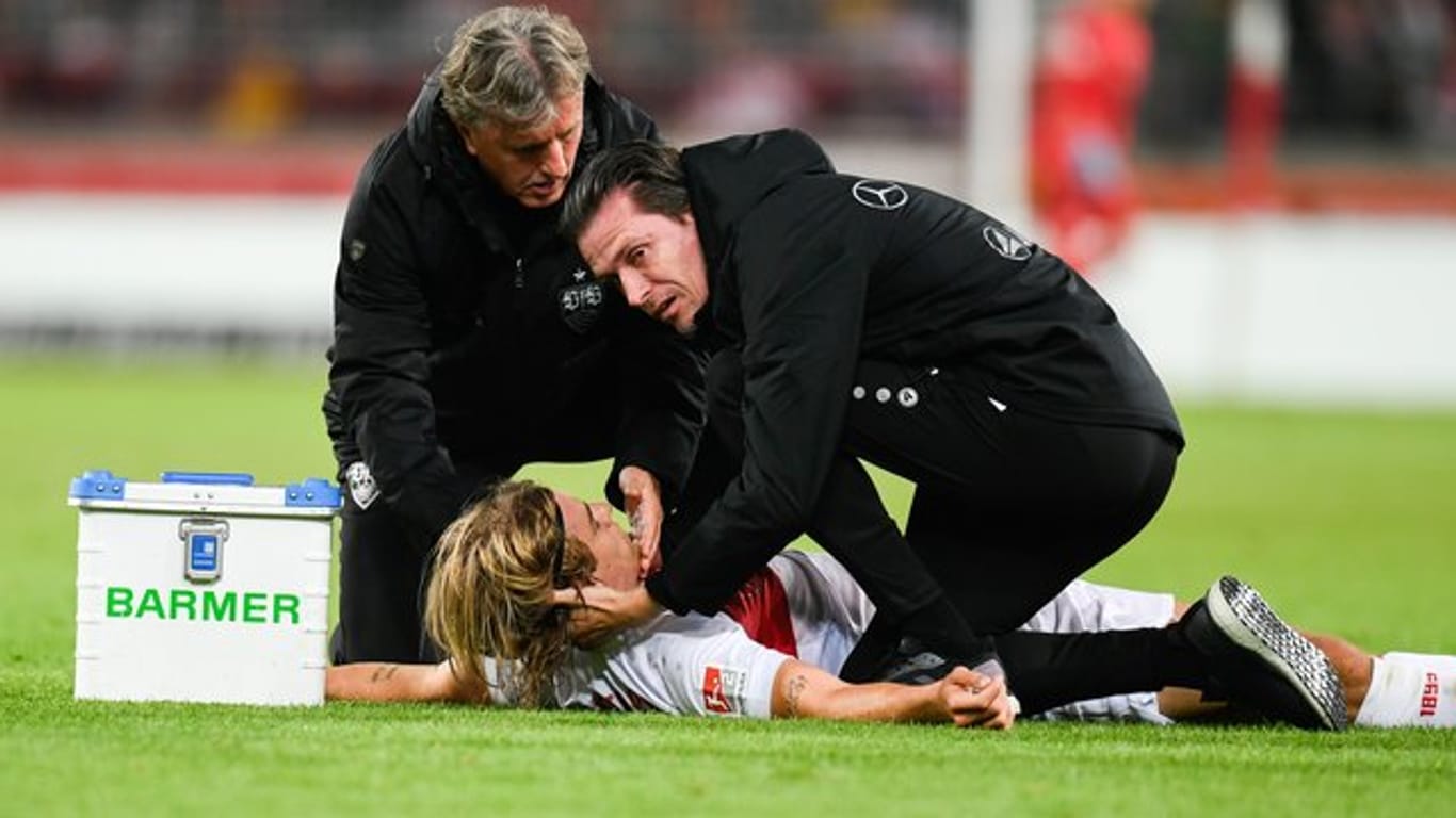 Borna Sosa vom VfB Stuttgart wird von den Mannschaftsärzten behandelt.