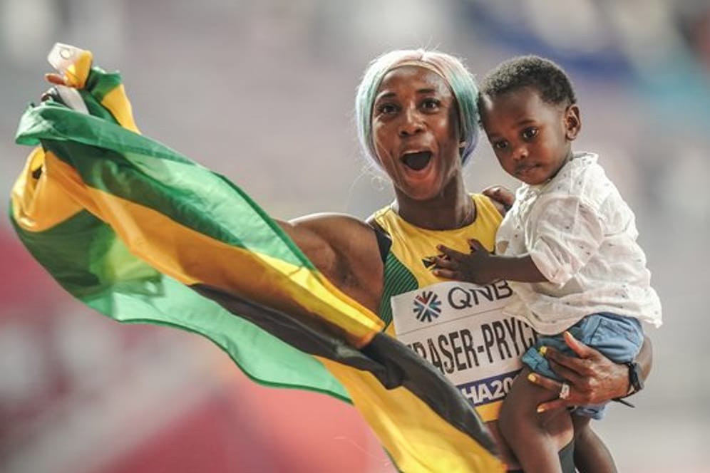 Sprint-Weltmeisterin Shelly-Ann Fraser-Pryce feiert ihren Erfolg mit ihrem Sohn Zyon auf dem Arm.