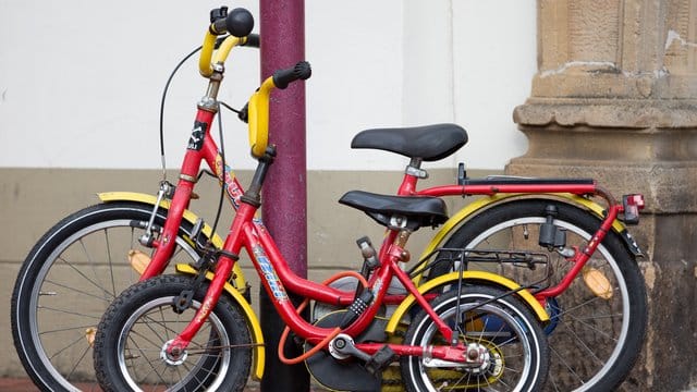 Zwei zusammengeschlossene Kinderfahrräder an einer Straßenlaterne. Zwei zusammengeschlossene Kinderfahrräder an einer Straßenlaterne.