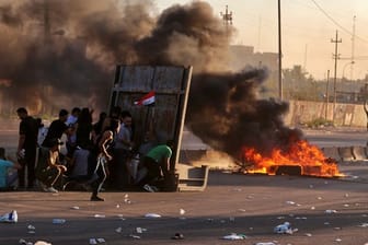 Regierungsfeindliche Demonstranten haben während einer Demonstration in Bagdad Feuer gelegt und eine Straße blockiert.