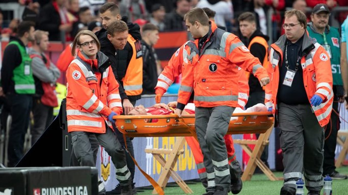 Leverkusens Charles Aranguiz wird verletzt vom Platz getragen.