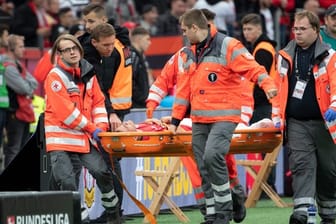 Leverkusens Charles Aranguiz wird verletzt vom Platz getragen.