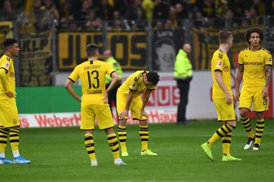 Sind sich selbst ein Rätsel: Die BVB-Spieler stehen nach dem Remis beim SC Freiburg mit hängenden Köpfen auf dem Spielfeld.